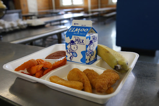 school lunch tray with fish sticks, banana, carrots and milk